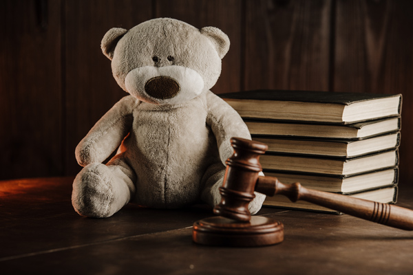 Divorce concept, wooden gavel and teddy bear as symbol of child on a desk
